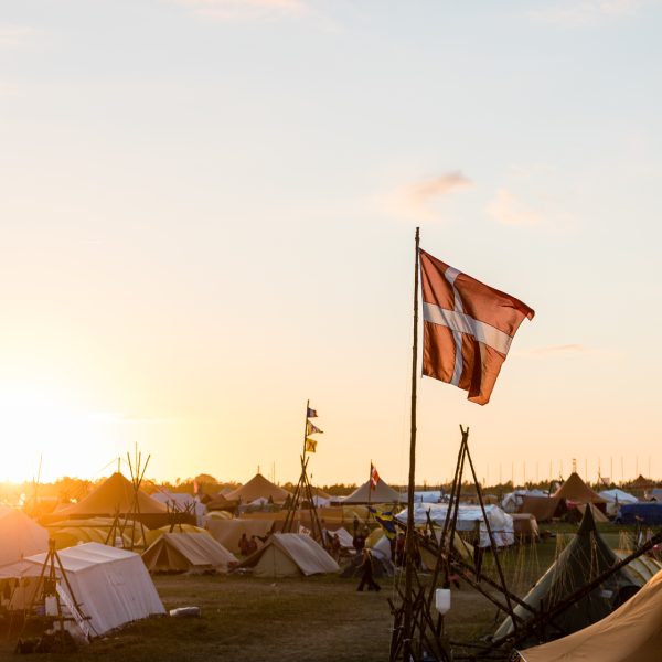 To spejderledere viser en færdselstavle for en gruppe børn